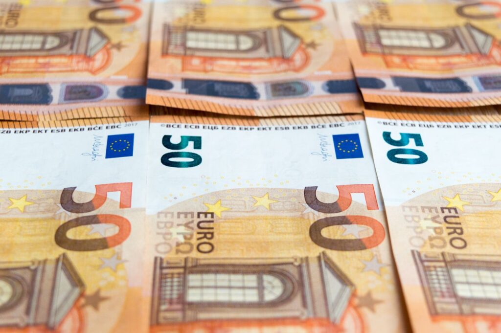 Detailed image of multiple 50 Euro bills stacked, showcasing currency design.