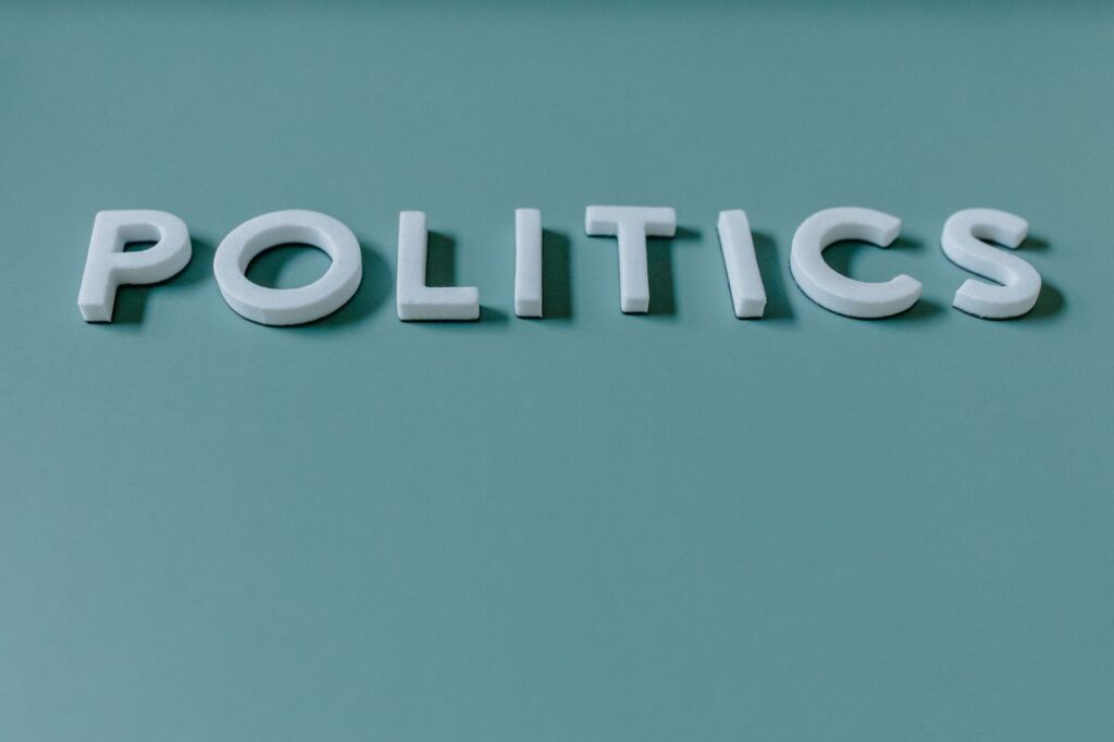 Close-up image of the word 'Politics' against a teal green background, highlighting political themes.