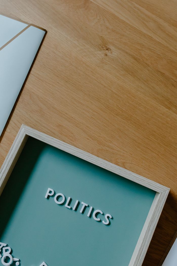 Mastering the First Impression: Your intriguing post title goes here A top view of a modern setup conveying political themes with a sign and tray on a wooden table.